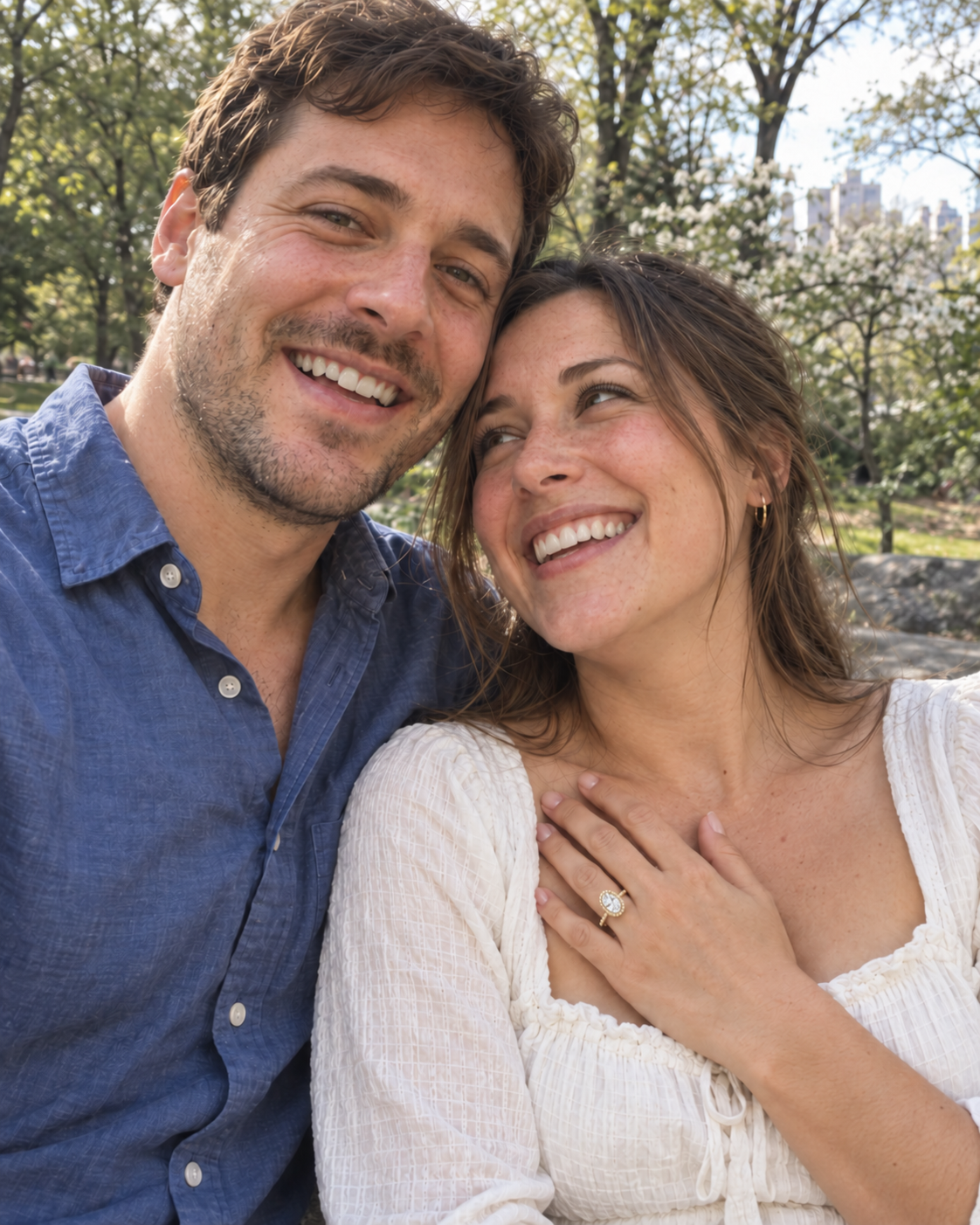 A couple outdoors, with the yellow-gold oval halo ring on her hand